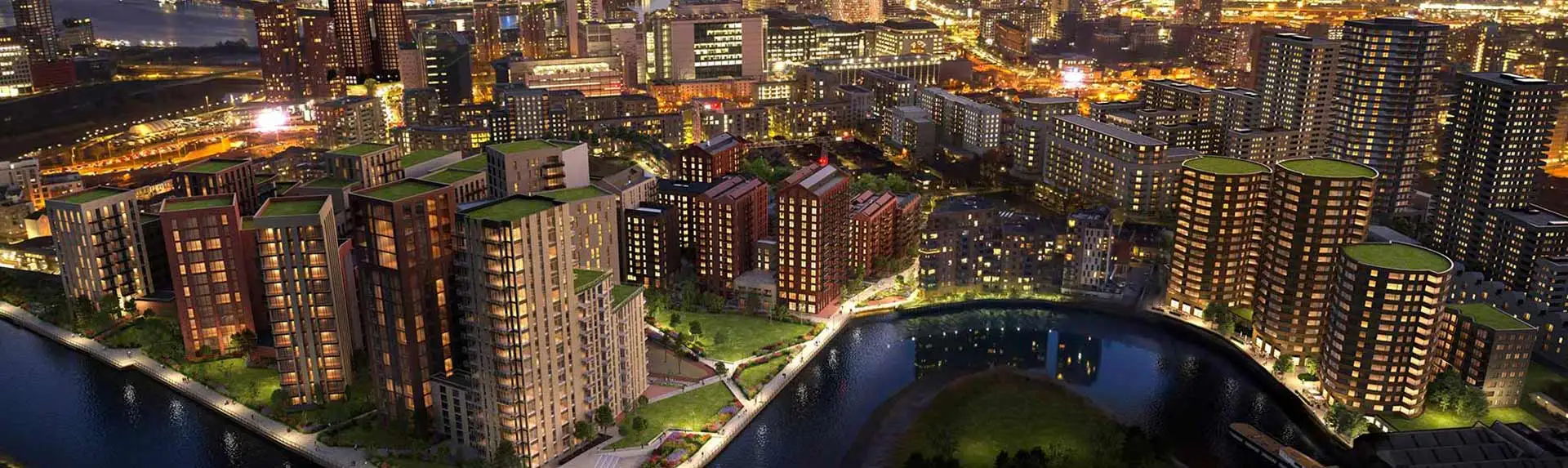 Night view of Heron Wharf, showcasing the illuminated riverside development and surrounding cityscape.